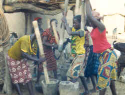 Pounding millet with mortar and pestl, to make prridge.